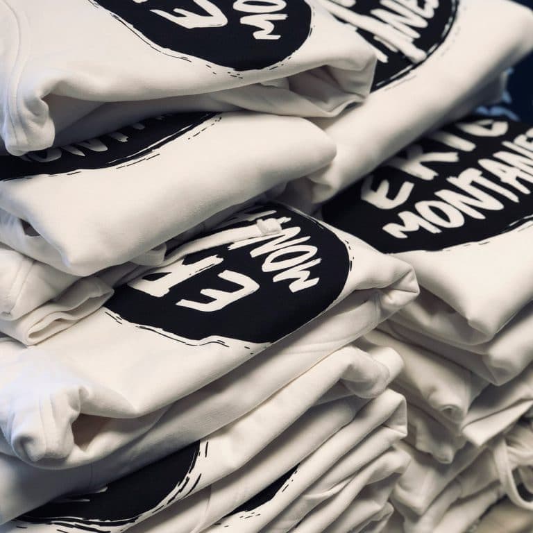 Stack of custom screen-printed apparel by Printology